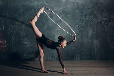 Young girl professional gymnast woman dance rhythmic gymnastics with ribbon at studio.の写真素材
