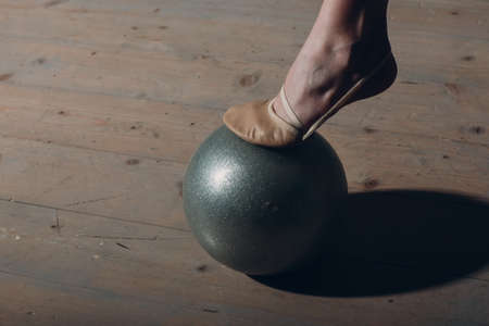 Young girl professional gymnast woman leg close up rhythmic gymnastics with ball at studio.の写真素材