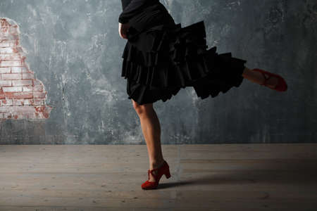 Young adult spanish woman dancing flamenco on gray vintage studio backgroundの写真素材
