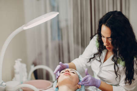 Young women getting face massage treatment in beauty spaの写真素材