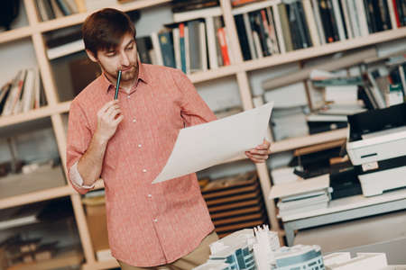 Architect with blueprints and layout design project at office bureau