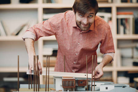 Architect with blueprints and layout design project at office bureau