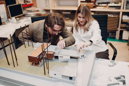Architect with blueprints and layout design project at office bureauの写真素材