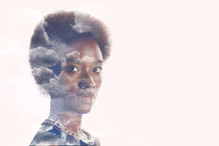 Multiple exposure image with clouds and sky inside african american woman portrait. Mental health and calm.の写真素材