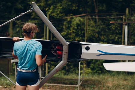 Sportsman single scull man rower prepare to competition with boat.の写真素材