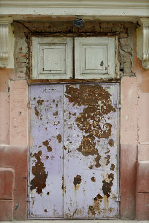 Old rusty heavy iron metal vintage painted shabby door.の写真素材
