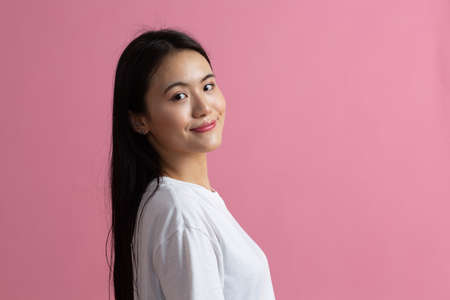 Portrait half turn of asian woman on pink background.の写真素材