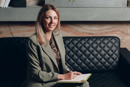 Business woman young adult coach sitting with notebook book at officeの写真素材