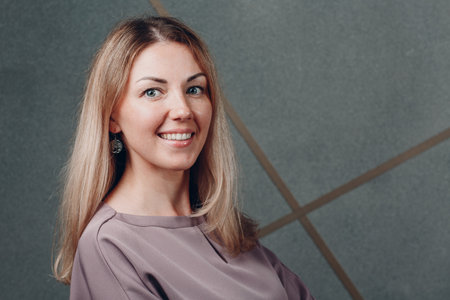Young adult caucasian european blonde smiling woman half turn face portraitの写真素材