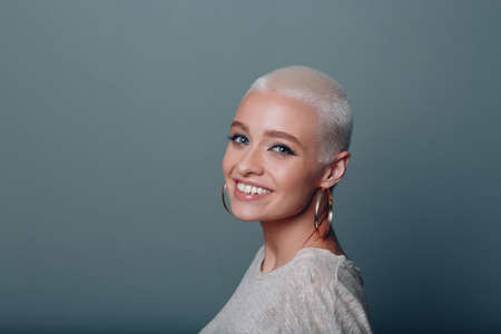 Millenial young european woman with short blonde hair smiling portraitの写真素材