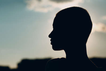 Portrait profile silhouette of young smiling millenial european short haired woman. Beautiful happy blonde girl outdoor. Summer fashion female clothing.の写真素材