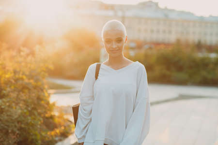 Portrait of young smiling millenial european short haired woman autumn september sunset. Beautiful happy blonde girl outdoor.の写真素材