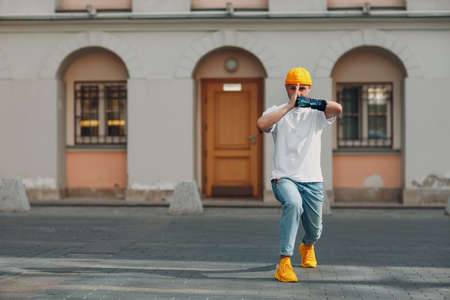 Young disabled karate man with artificial prosthetic hand in casual clothes at outdoor city street. Martial arts conceptの写真素材