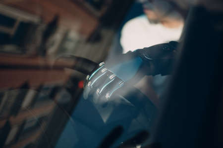 Young disabled man driver with artificial prosthetic hand driving vehicle car hand on steering wheelの写真素材