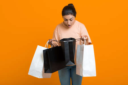 Indian woman looking shopping bags in hands. Sale and Black Friday conceptの写真素材
