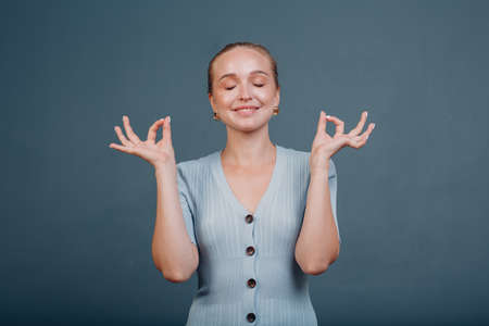 Adult young woman smile portrait in studio with yoga meditation ok mudraの写真素材