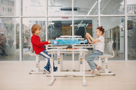 Smiling kids boy and girl child constructor checking technical toy. Children Robotics constructor assemble robotの写真素材