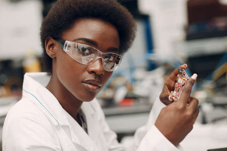 Scientist african american woman working in laboratory with electronic board. Research and development of electronic devices by color black woman.の写真素材