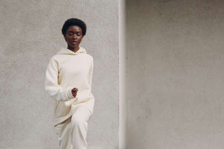 Young african american woman stretching and warming up outdoor. Fitness and outside sport healthy lifestyle concept.の写真素材