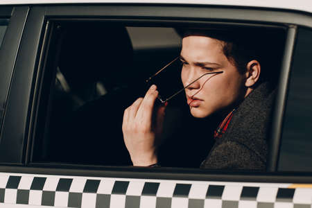 Portrait of a handsome young man riding in the backseat of taxiの写真素材