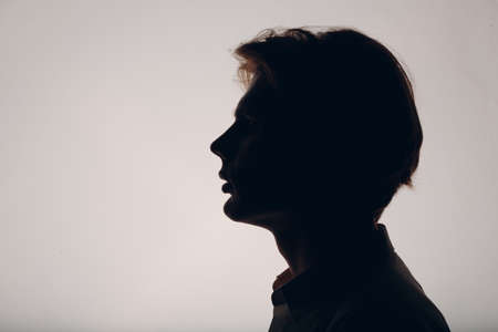 Portrait european young man portrait profile silhouette dark at studioの写真素材