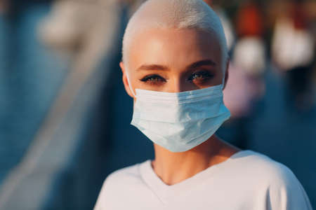 Portrait of young smiling millenial european short haired woman. Beautiful happy blonde girl outdoor. Summer fashion face covering female clothing.の写真素材