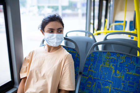 Indian Woman ride in public transport bus or tram in medical face covering maskの写真素材