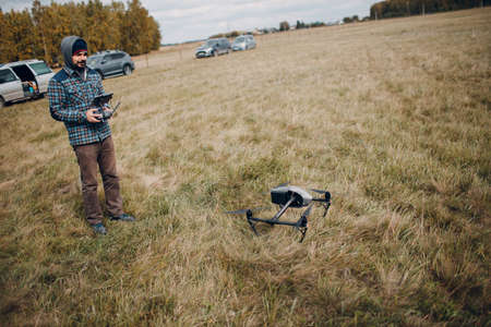 Man pilot controlling quadcopter drone with remote controller pad.の写真素材