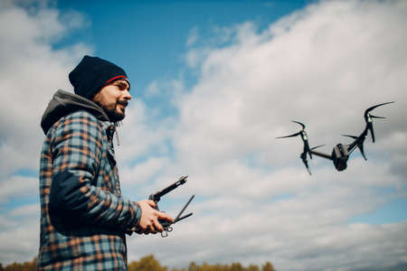 Man pilot controlling quadcopter drone with remote controller pad.の写真素材