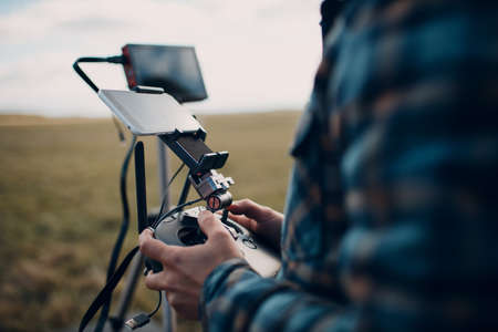 Man pilot controlling quadcopter drone with remote controller pad.の写真素材