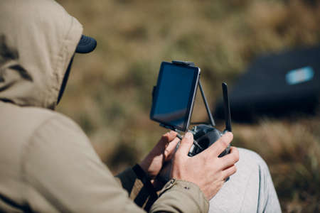 Man pilot controlling quadcopter drone with remote controller pad.の写真素材