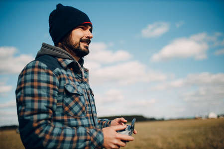 Man pilot controlling quadcopter drone with remote controller pad.の写真素材