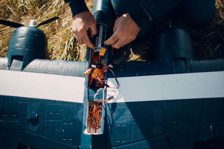 Radio control rc airplane toy model on ground mancheck and replace battery aircraft overhead view