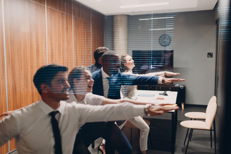 Businessman and businesswoman team doing warm-up and yoga exercises before office meeting. Business healthy successful people group man and woman after conference discussion with boss.の写真素材