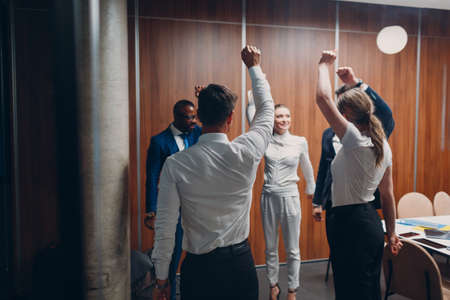 Businessman and businesswoman team doing warming up exercises before office meeting. Business healthy successful people group man and woman after conference discussion with boss.の写真素材