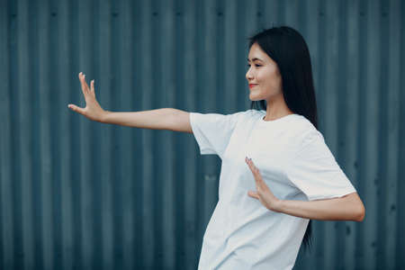Asian young woman doing qigong wushu Taijiquan exercise summer outdoor.の写真素材