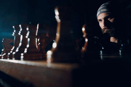 Young adult man play chess in darkの写真素材
