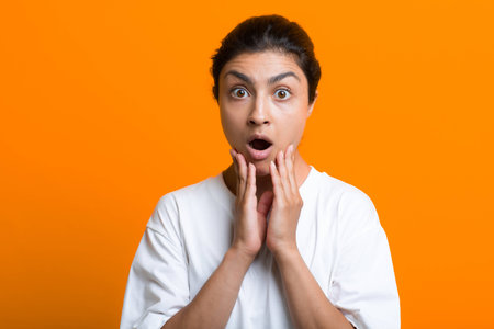 Portrait of young surprised scared adult indian woman in T-shirtの写真素材