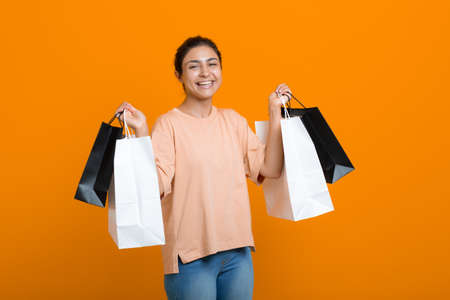 Indian woman holds shopping bags in hands. Sale and Black Friday conceptの写真素材