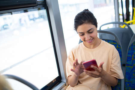 Indian Woman ride in public transport bus or tram with mobile phoneの写真素材