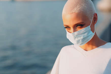 Portrait of young smiling millenial european short haired woman. Beautiful happy blonde girl outdoor. Face covering.の写真素材