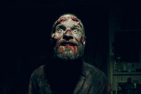 Zombie man portrait in darkness with makeup for halloween party