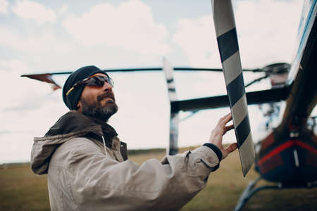 Portrait of helicopter pilot standing near vehicle in field airport.の写真素材