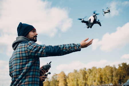 Man pilot Launches quadcopter drone from hand to sky flightの写真素材
