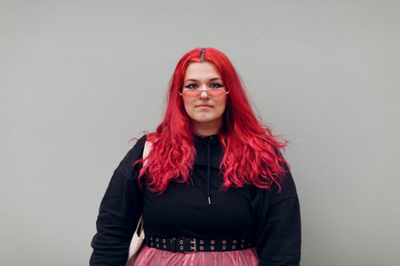Plus size overweight fat bold body positive lgbtq woman with red hair and pink glasses.の写真素材