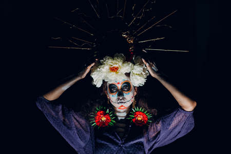 Woman with mexican skull halloween makeup on dark background. Day of the dead aka Dia de Muertos and halloween traditional celebrationの写真素材