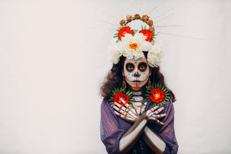 Woman with mexican skull halloween makeup on white background. Day of the dead aka Dia de los Muertos and halloween carnival concept.の写真素材