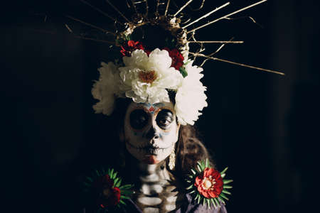 Woman with mexican skull halloween makeup on face. Day of the dead aka Dia de los Muertos and halloween concept.の写真素材