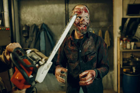 Zombie and chainsaw defence halloween concept. Make up skin and blood faceの写真素材