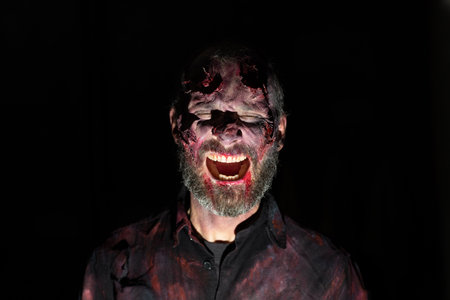 Zombie man portrait in darkness with makeup for halloween partyの写真素材